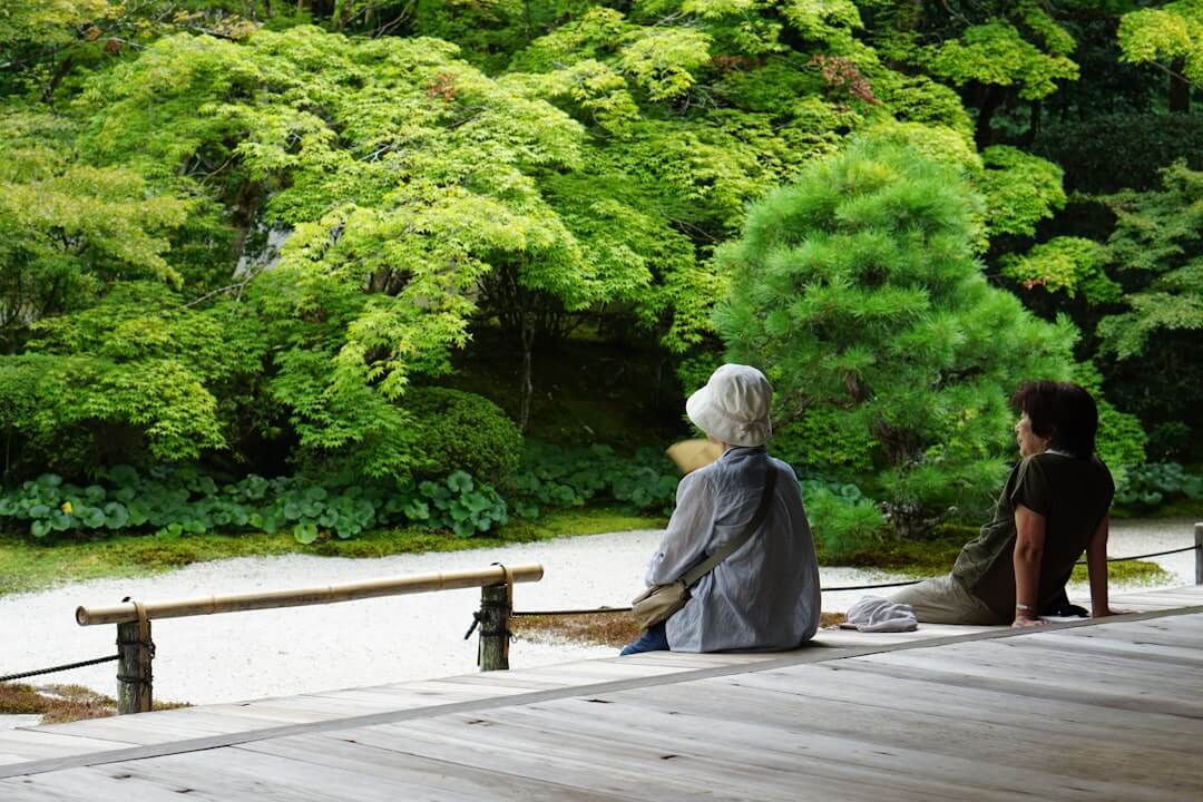 Two people sitting quietly overlooking a garden landscape